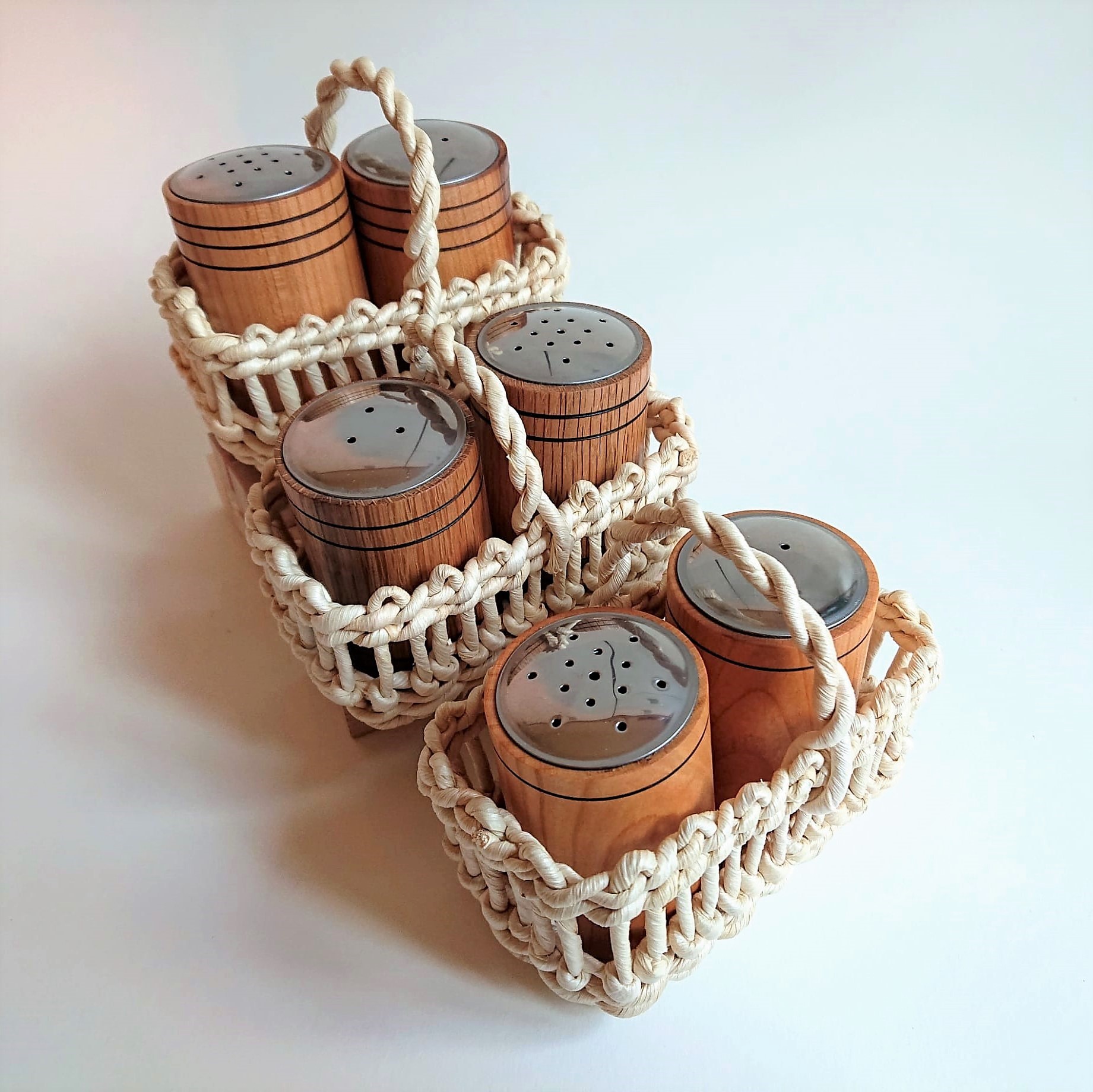 Salz und Pfefferstreuer aus vers. Holzsorten in Maiskörbchen gesteckt und treppenförmig dargestellt