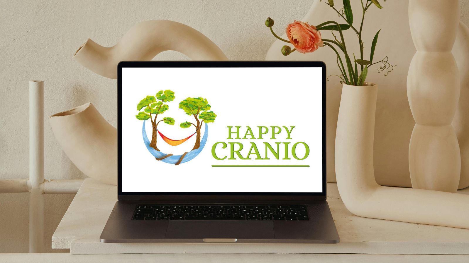 Happy Cranio Online Coaching - Happy Cranio Logo auf Laptop auf hellen Schreibtisch